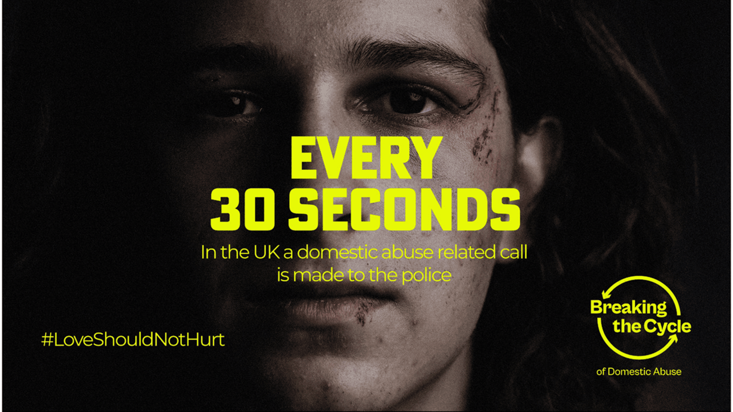 Close-up of a person's face with visible bruising, overlaid with text 'Every 30 seconds, in the UK a domestic abuse related call is made to the police' and hashtag #LoveShouldNotHurt, with the Breaking the Cycle of Domestic Abuse logo.
